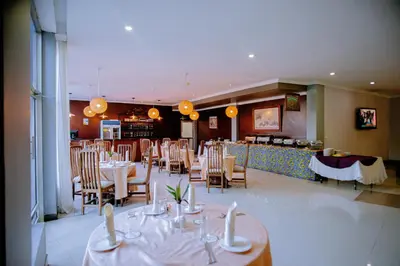 a dining room with tables and chairs in a restaurant at Corridor Springs Hotel in Arusha