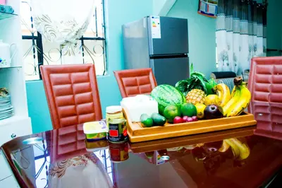 a kitchen with a table with fruits and vegetables at Catherine home near kilimanjaro international airport JRO in Moshi