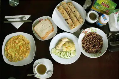 a table with plates of food and cups of coffee at Catherine home near kilimanjaro international airport JRO in Moshi