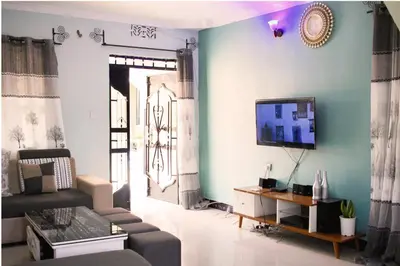 a living room with a couch and a tv on a wall at Catherine home near kilimanjaro international airport JRO in Moshi