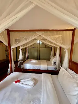 a bedroom with two beds with white sheets at Patamu Restaurants Lodge & Safaris in Karatu