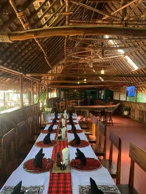 a long table with black birds sitting on top of it at Patamu Restaurants Lodge & Safaris in Karatu