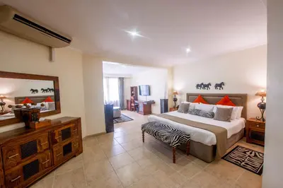 a bedroom with a large bed with a zebra print pillow at African Tulip Hotel in Arusha