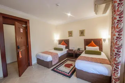 a hotel room with two beds and a doorway at African Tulip Hotel in Arusha