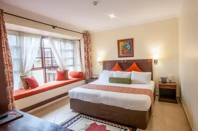 a hotel room with a bed and a window at African Tulip Hotel in Arusha