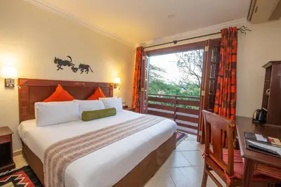 a bedroom with a large bed and a window at African Tulip Hotel in Arusha