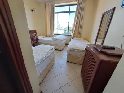 a hotel room with two beds and a window at Moshi Leopard Hotel in Moshi