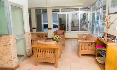 a room with benches and tables and windows at Moshi Leopard Hotel in Moshi
