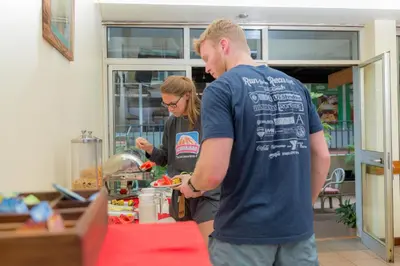 a man and a woman preparing food in a kitchen at Moshi Leopard Hotel in Moshi
