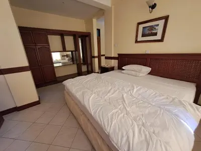 a bedroom with a large bed with white sheets at Moshi Leopard Hotel in Moshi