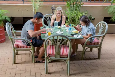 a group of people sitting around a table eating food at Moshi Leopard Hotel in Moshi