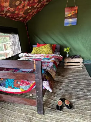a bedroom with a bed in a tent with two slippers at Uvi House & Restaurant in Mntindili