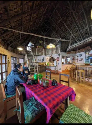 two people sitting at a table in a room at Uvi House & Restaurant in Mntindili