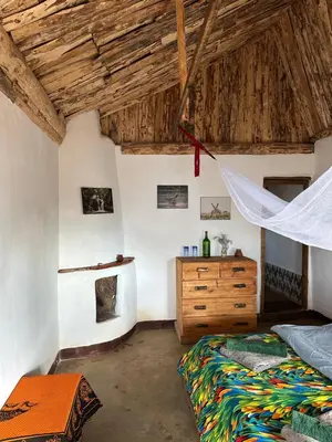 a bedroom with a bed and a wooden dresser at Uvi House & Restaurant in Mntindili