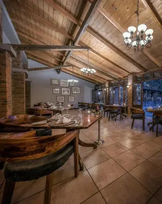 a dining room with a large wooden table and chairs at Elewana Arusha Coffee Lodge in Arusha
