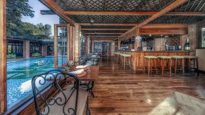 a pool house with a bar and a swimming pool at Elewana Arusha Coffee Lodge in Arusha