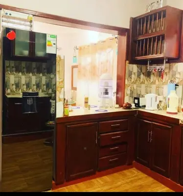 a kitchen with wooden cabinets and a counter top at Tamaduni Homestay & Lodge in Arusha