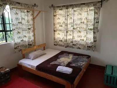 a bedroom with a bed in a room with curtains at Tamaduni Homestay & Lodge in Arusha