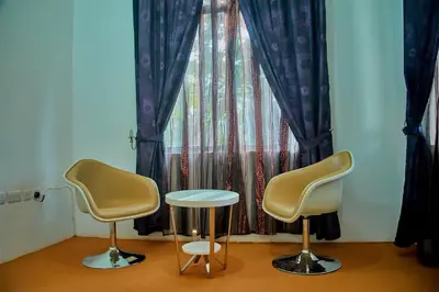 two chairs and a table in front of a window at NGORONGORO CORRIDOR LODGE Karatu in Karatu