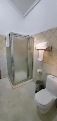 a bathroom with a shower and a toilet at NGORONGORO CORRIDOR LODGE Karatu in Karatu