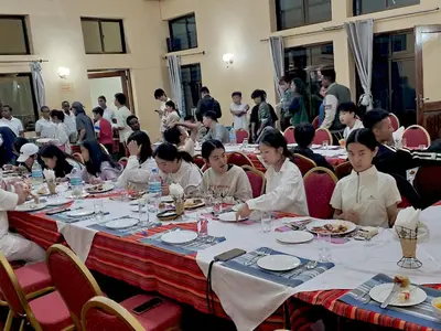 a group of people sitting at tables in a room at NGORONGORO CORRIDOR LODGE Karatu in Karatu