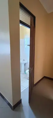 a door leading to a bathroom with a toilet at Kilimanjaro Budget Lodge in Msaranga