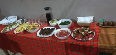a table with plates of food on a red table cloth at Kilimanjaro Budget Lodge in Msaranga