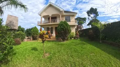 a house with a green lawn in front of it at Kili Kivuli in Msaranga