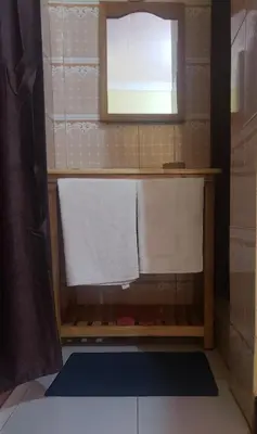 a bathroom with a towel rack and a window at Biez Homestay in Karatu