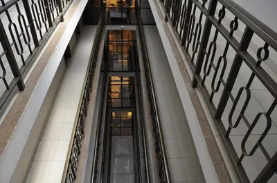 an escalator in a building with many windows at Rich Hotel in Arusha