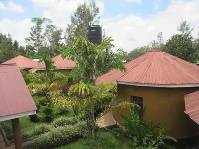 a group of houses with red roofs and trees at Kilimanjaro Eco Lodge in Usa River