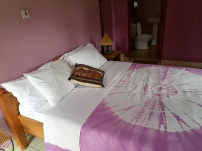 a bed with a blanket and a purse on it at Kilimanjaro Eco Lodge in Usa River