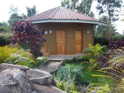 a small building with a door in a garden at Kilimanjaro Eco Lodge in Usa River