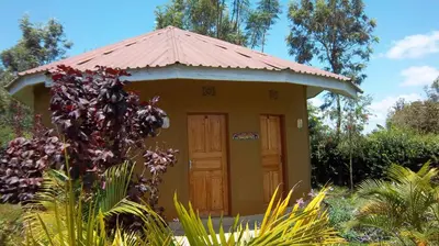 a small yellow building with a red roof at Kilimanjaro Eco Lodge in Usa River