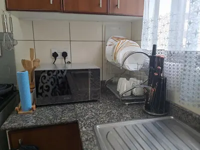 a kitchen counter with a microwave and other kitchen appliances at Logic Stays 2 Bedroom Arusha City Centre in Arusha