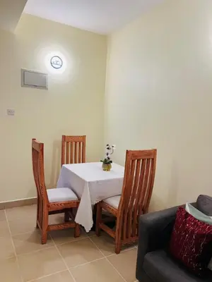 a dining room with a table and two chairs at Logic Stays 2 Bedroom Arusha City Centre in Arusha