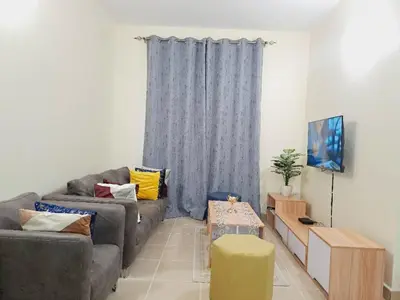 a living room with a couch and a tv at Logic Stays 2 Bedroom Arusha City Centre in Arusha