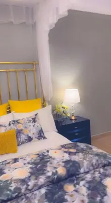 a bedroom with a bed and a lamp and flowers at Amala villas in Arusha
