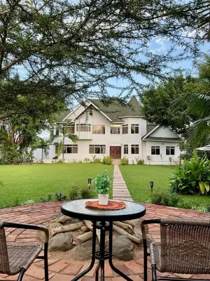 a patio with a table and chairs in front of a house at Amala villas in Arusha