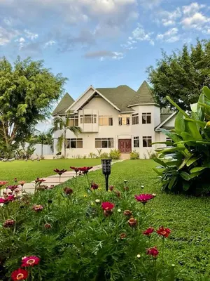 a large house with flowers in the yard at Amala villas in Arusha