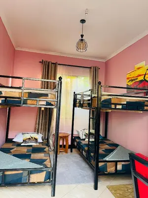 a bedroom with three bunk beds in a room at KILIMANJARO HOME OF RASON in Msaranga