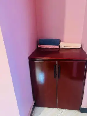 a small red cabinet in a room with a pink wall at KILIMANJARO HOME OF RASON in Msaranga