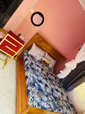 a bedroom with a bed with a wooden frame at KILIMANJARO HOME OF RASON in Msaranga