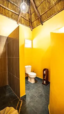 a bathroom with a toilet and a yellow wall at Africa Safari Rift Valley in Magara