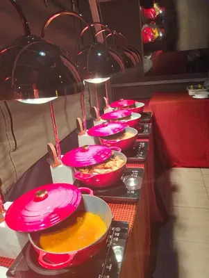 a buffet line with pink plates and bowls of food at Africa Safari Rift Valley in Magara