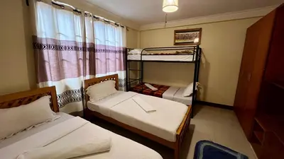 a bedroom with two bunk beds and a window at Runako Hostel in Arusha