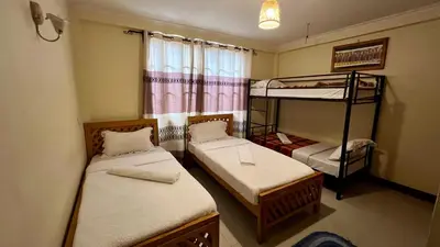 a room with two bunk beds and a window at Runako Hostel in Arusha