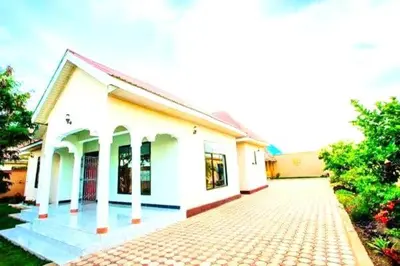 a white house with a brick driveway in front of it at Safi House in Boma la Ngombe