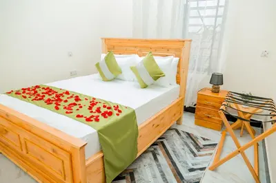 a bedroom with a bed with red flowers on it at Safi House in Boma la Ngombe