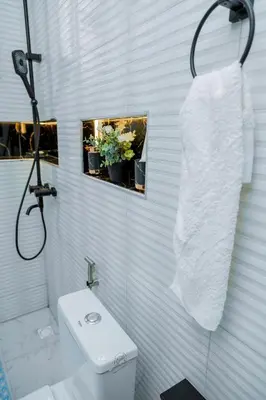 a white bathroom with a toilet and a sink at Safi House in Boma la Ngombe